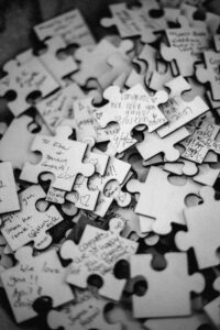 A pile of white puzzle pieces with names of guest written on them.